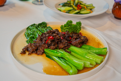Spicy Cumin Beef with tender greens in a rich sauce, an authentic Chinese dish at Mo Jasmine Zurich.
