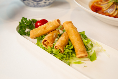 Crispy Chinese Spring Rolls served on fresh lettuce, a popular appetizer at Mo Jasmine Zurich.