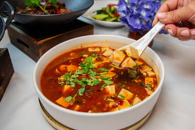 Spicy Mapo Tofu, a classic Sichuan dish with soft tofu cubes in a fiery chili bean sauce, served at Mo Jasmine Zurich.