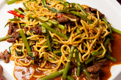 Authentic Chinese Noodles with spicy beef and water spinach (or similar greens) in a rich sauce, from Mo Jasmine Zurich.
